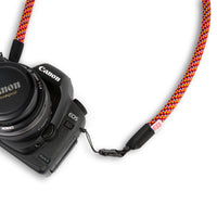 General shot of Topo Designs Camera Strap in Red/Turquoise attached to a Canon EOS camera.