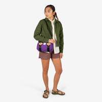 General shot of Topo Designs Mini Classic Duffel Bag shoulder crossbody purse in Purple held by model with shoulder strap.