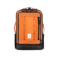Topo Designs Global Travel Bag 30L Durable Carry On Convertible Laptop Travel Backpack in "Clay" orange.