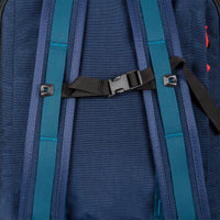 General shot of sternum strap on backpack straps of Topo Designs Global Travel Bag Roller durable carry-on convertible laptop rolling suitcase in Navy blue.