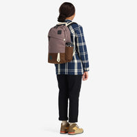 General shot of model wearing Topo Designs Daypack Classic 100% recycled nylon laptop backpack for work or school in "Peppercorn / Cocoa".