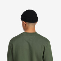 Back model shot of Topo Designs Global Beanie merino wool blend watchman cap in "black"