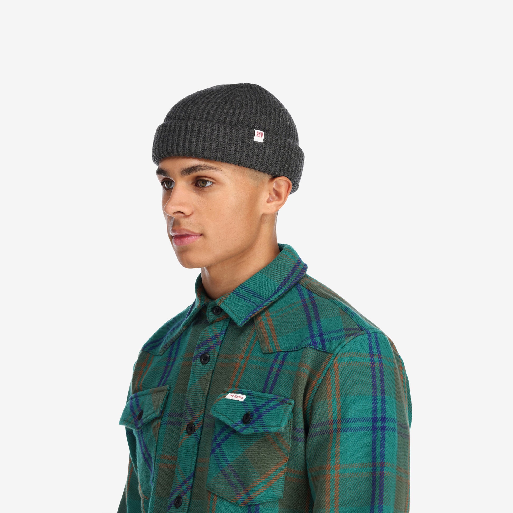 Side model shot of Topo Designs Global Beanie merino wool blend watchman cap in "charcoal" gray