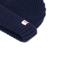 General detail shot of map logo label on Topo Designs Global Beanie merino wool blend watchman cap in "navy" blue