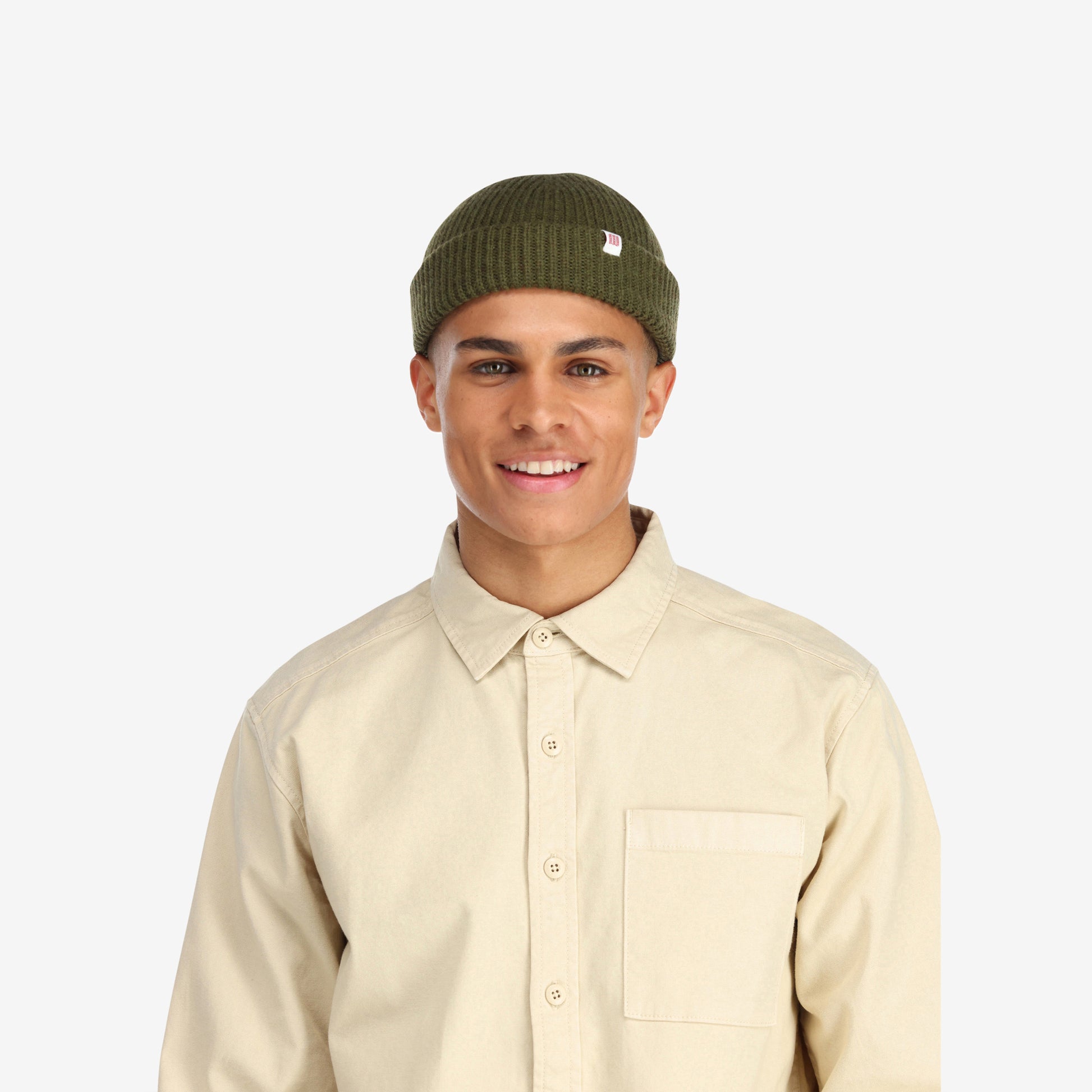 Front model shot of Topo Designs Global Beanie merino wool blend watchman cap in "olive" green.