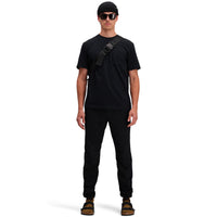 Front model shot of Topo Designs Men's Dirt Pocket Tee 100% organic cotton short sleeve t-shirt in "black". Show on "pond blue"