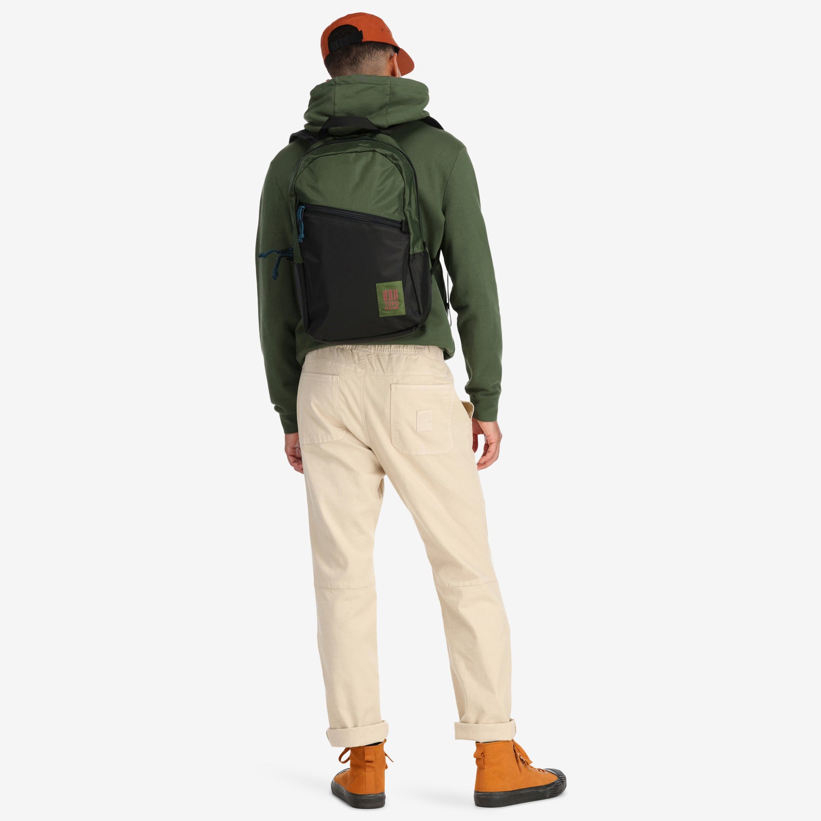 General shot of Topo Designs Light Pack laptop backpack in "black / olive" green on model shown from back.