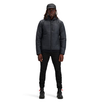 Model wearing Topo Designs Men's Global Puffer packable recycled insulated Hoodie jacket in "black"