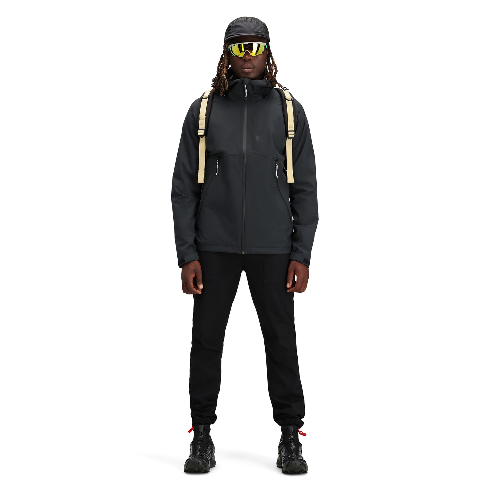 General shot Model wearing Topo Designs Men's Global Jacket packable 10k waterproof rain shell in recycled "black" polyester.