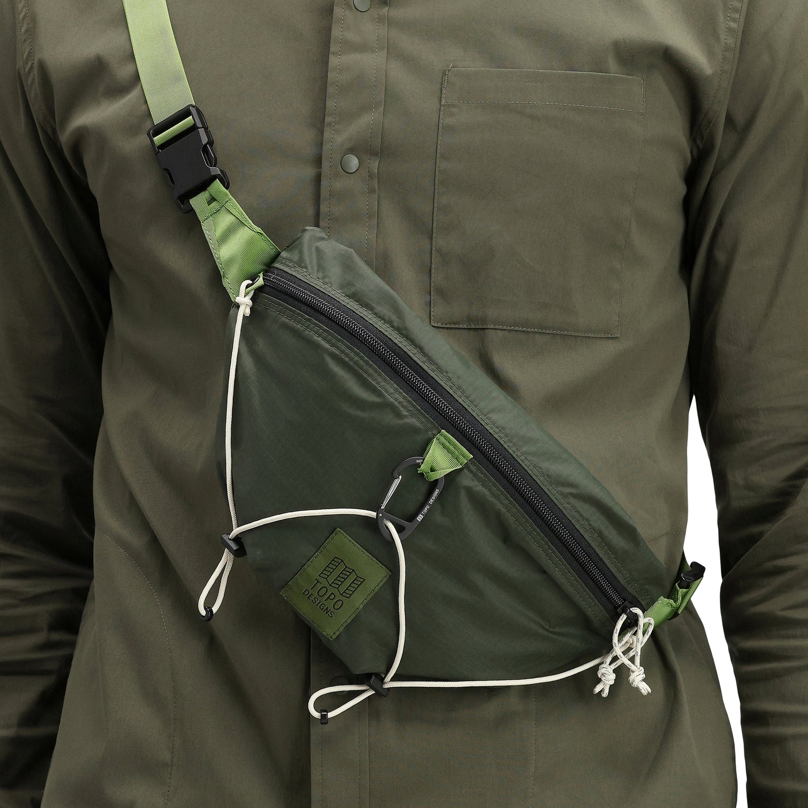 General detail of model wearing Topo Designs TopoLite Hip Pack Ultralight fanny pack crossbody bum bag in "olive" green. 