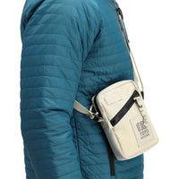 Side model shot of Topo Designs Men's Global Puffer packable recycled insulated Hoodie jacket in "pond blue". 
