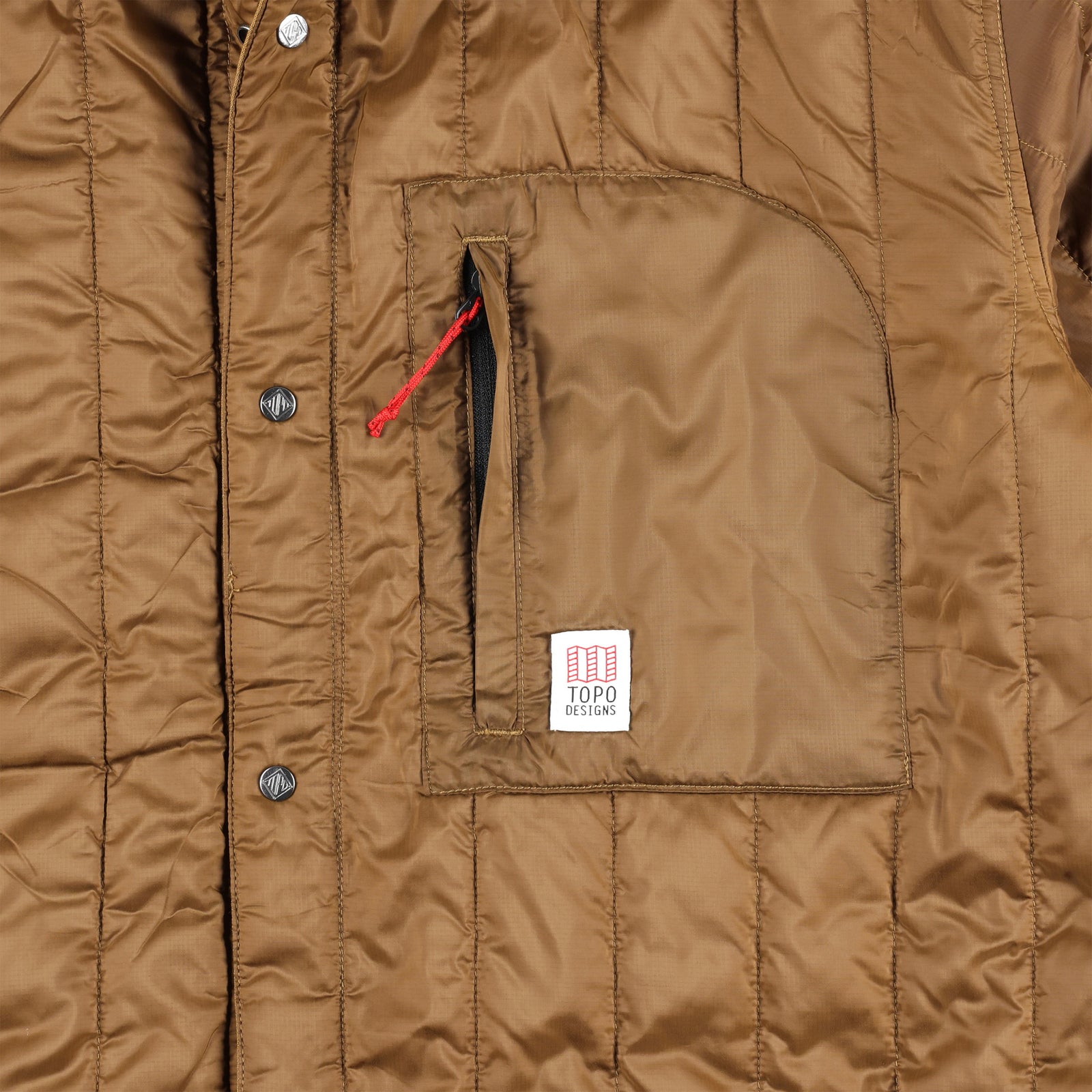 Detail shot of chest zipper pocket on Front model shot of Topo Designs Men's Insulated Reversible Shirt Jacket in "dark khaki" brown