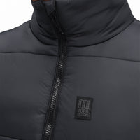General front detail shot of Topo Designs Men's Mountain Puffer recycled insulated Vest in "Black" showing zipper and chest logo.