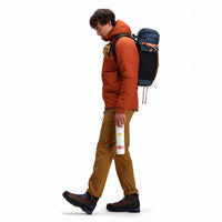 Side model shot of Topo Designs Mountain Puffer Primaloft insulated Hoodie jacket in "Brick" orange