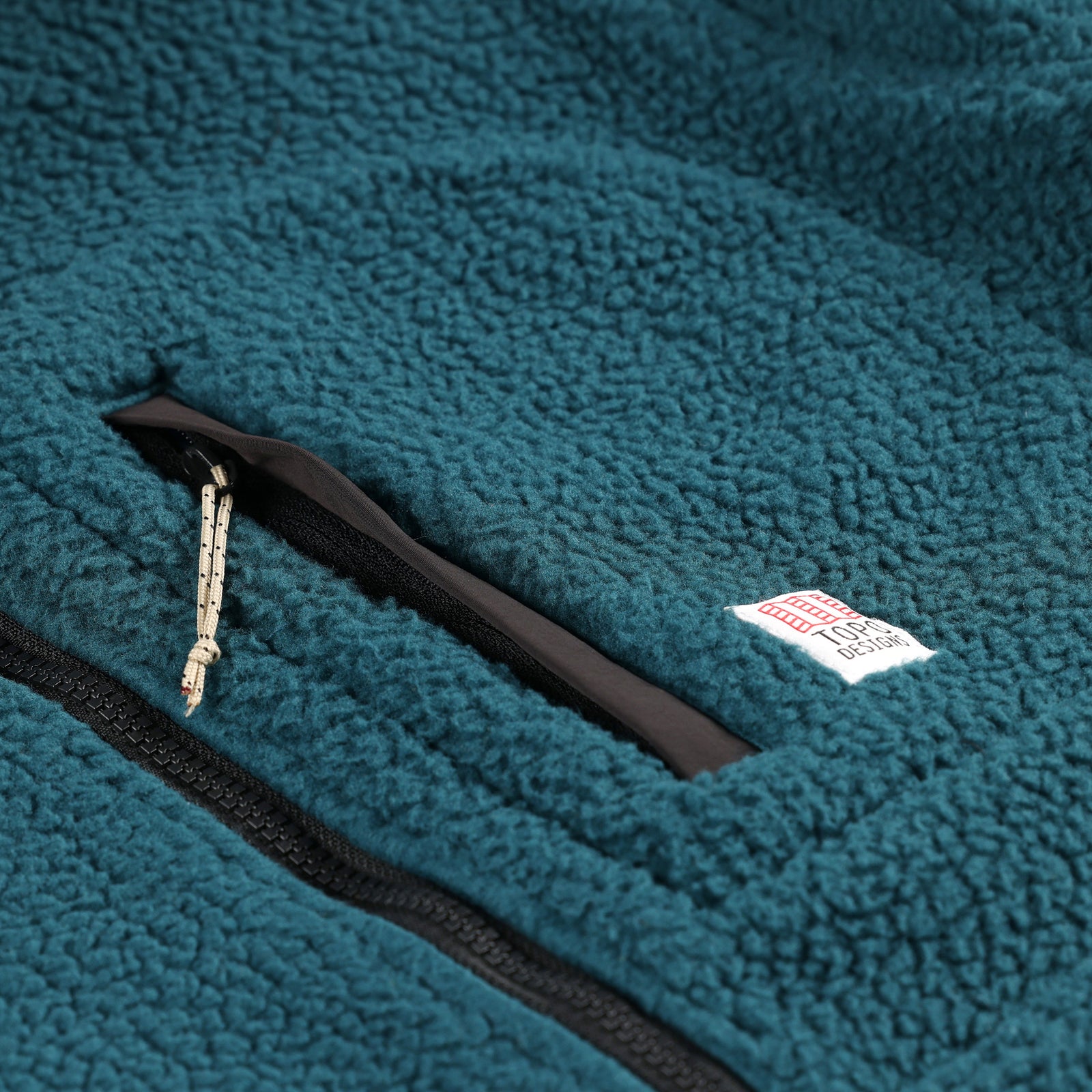 General detail shot of the chest zipper pocket on Topo Designs Men's Mountain Fleece Pullover in "Pond Blue".