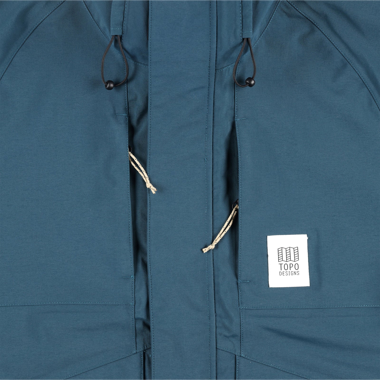 General detail shot of chest zipper pockets on Topo Designs Men's Mountain Parka waterproof shell jacket in "Pond Blue"