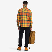 Back model shot of Topo Designs men's mountain organic cotton flannel shirt in "brick / mustard plaid" orange. Show on "blue multi" and "red multi"