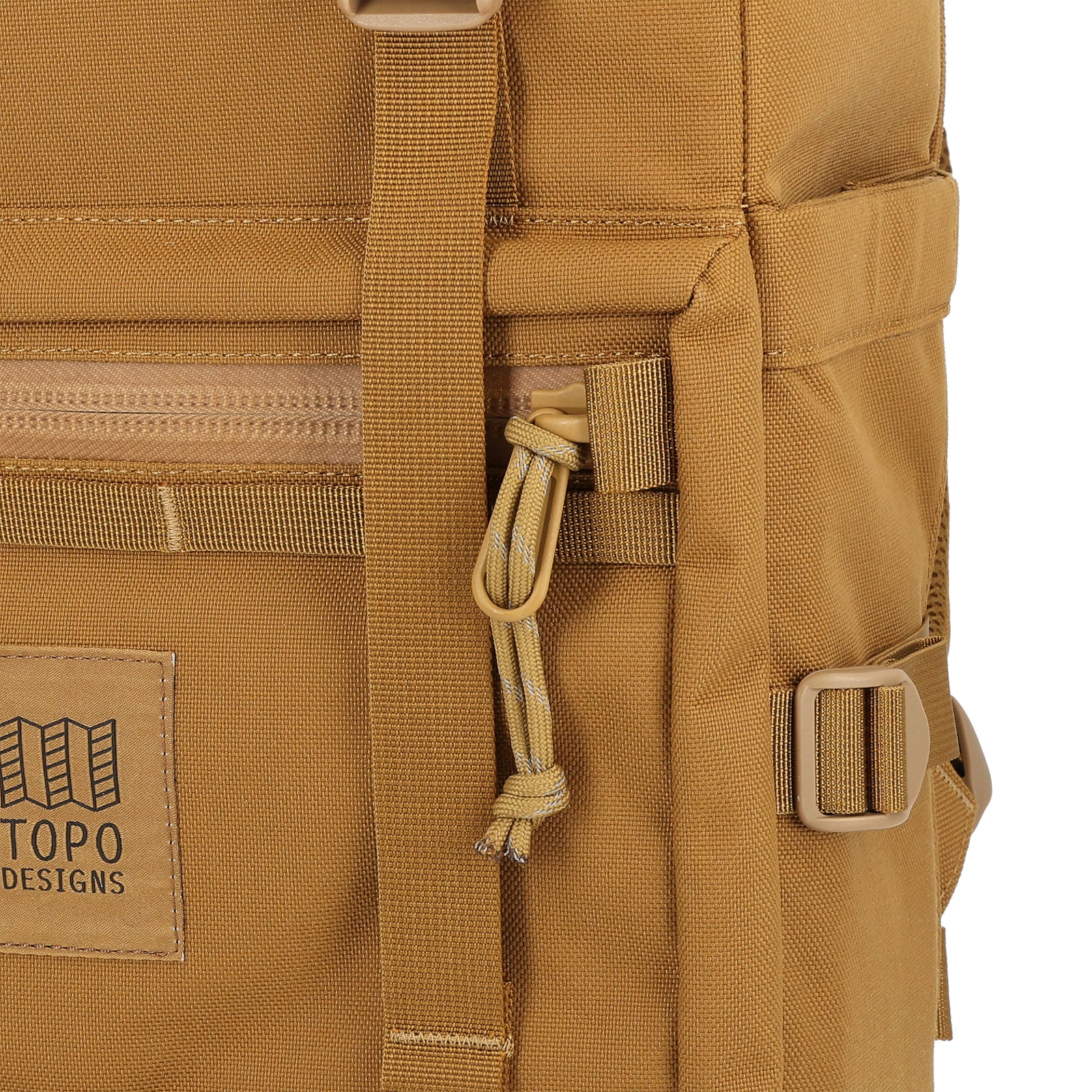 General detail Shot of the Topo Designs Rover Pack Tech in "Dark Khaki" brown showing front logo patch, zipper pulls, and daisy chain webbing.
