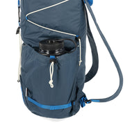 General detail shot of side water bottle pocket on Topo Designs TopoLite Cinch Pack 16L packable daypack backpack for travel in "pond blue"