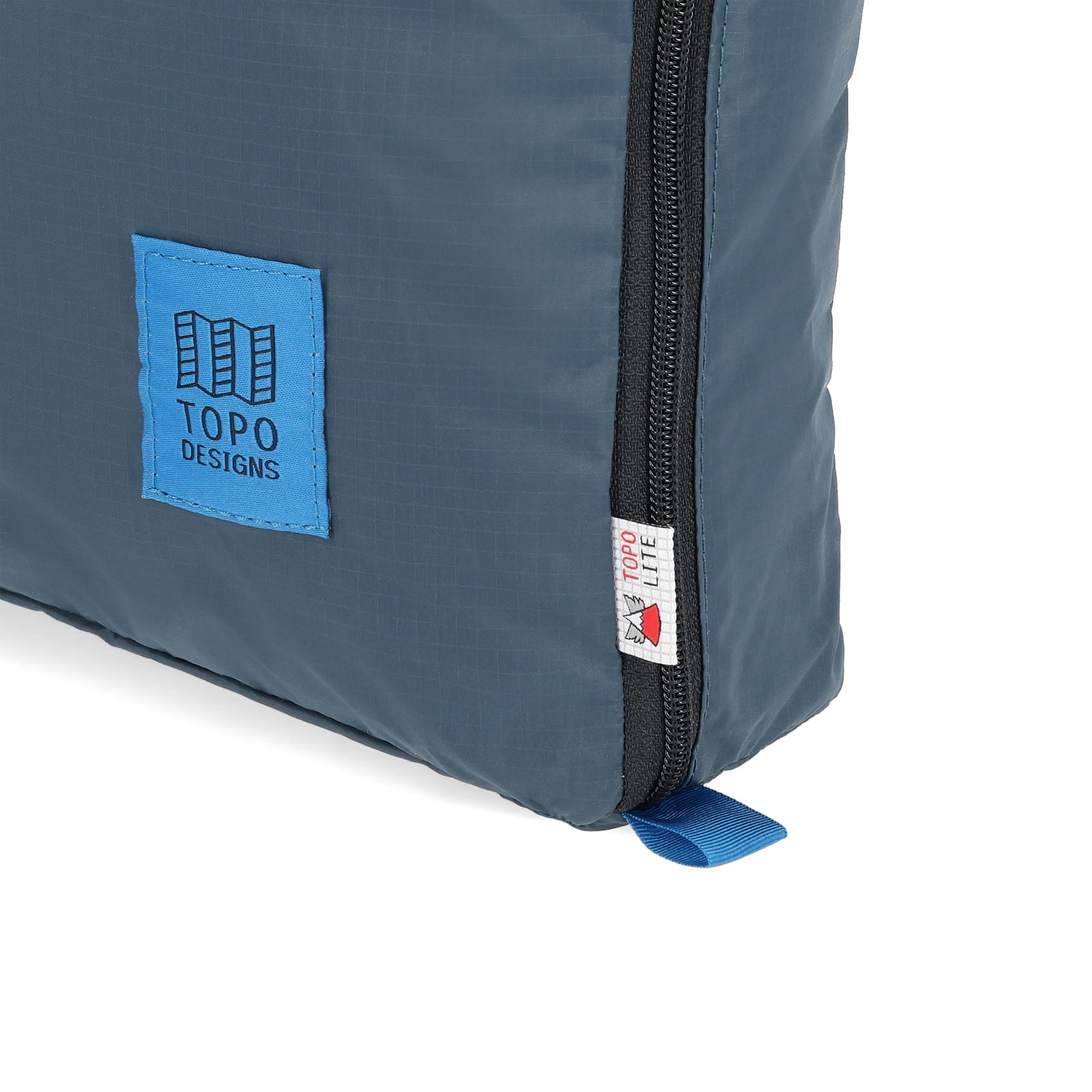 General detail shot of logos on Topo Designs TopoLite 10L Pack Bag ultralight packing cube for travel in "pond blue"