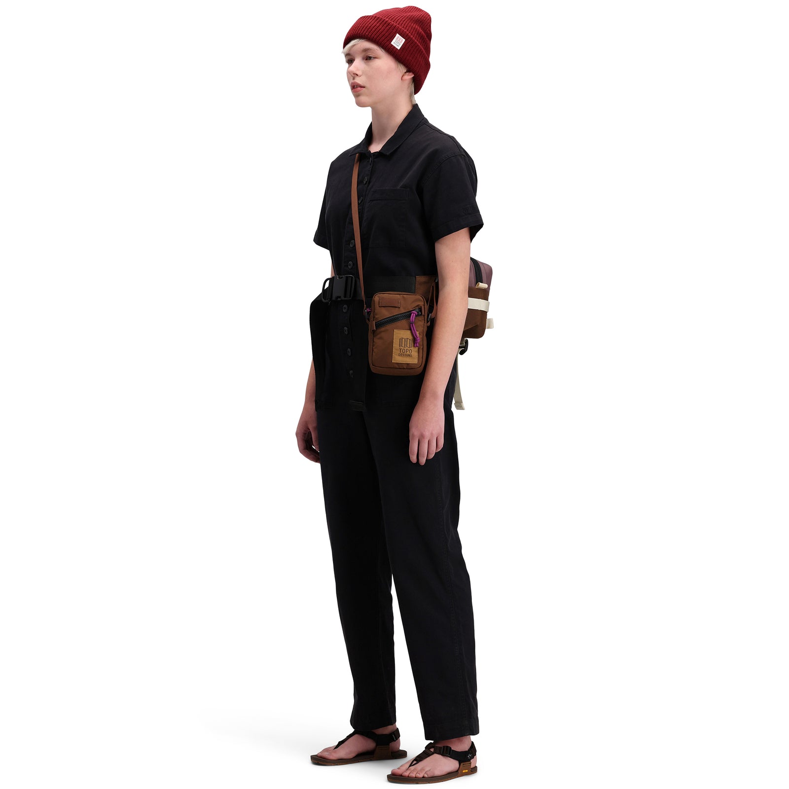 Side model shot of Topo Designs Women's Dirt Coverall 100% organic cotton short sleeve jumpsuit in "black"
