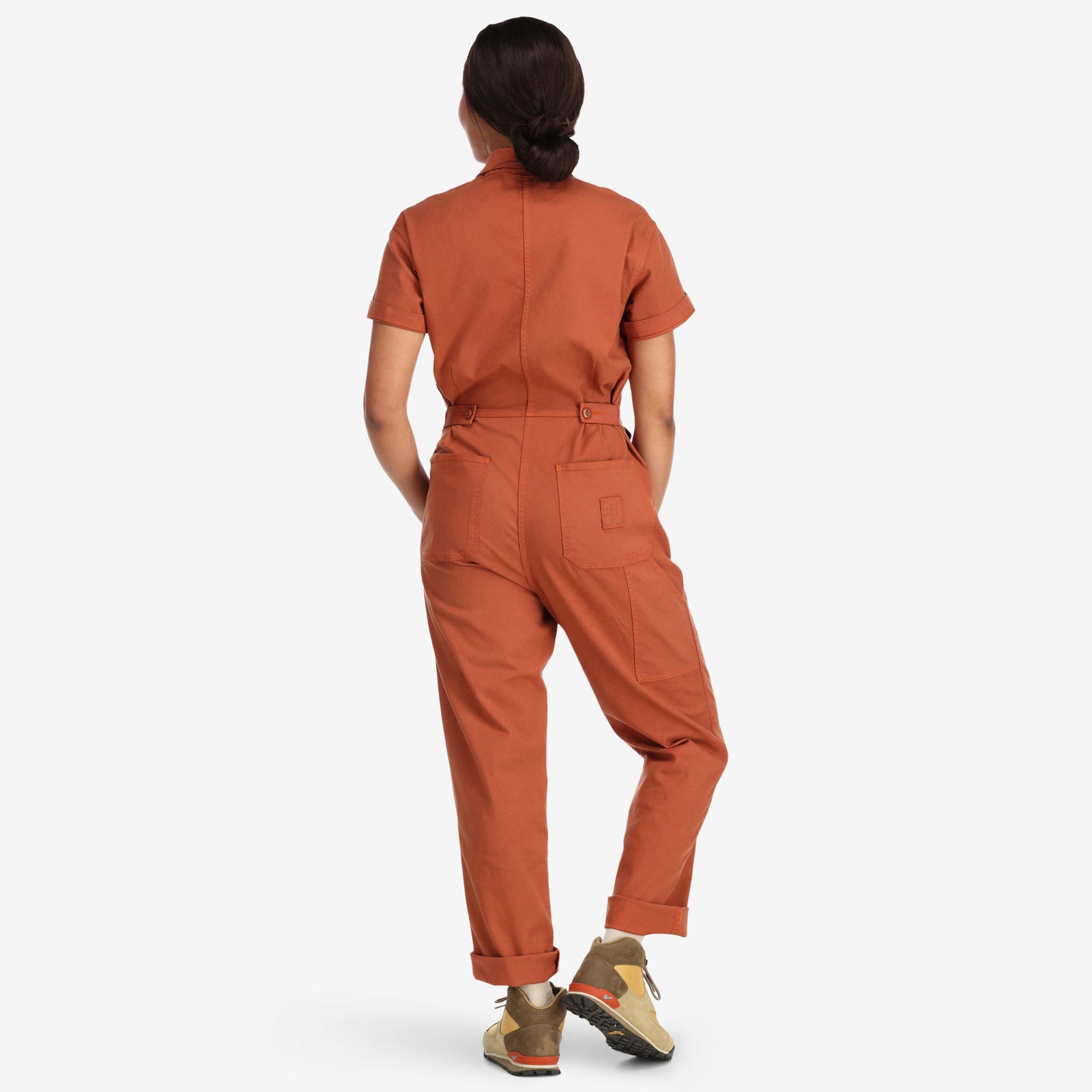 Back model shot of Topo Designs Women's Dirt Coverall 100% organic cotton short sleeve jumpsuit in "brick" orange