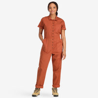 Front model shot of Topo Designs Women's Dirt Coverall 100% organic cotton short sleeve jumpsuit in "brick" orange