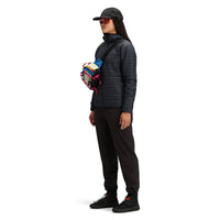 Side model shot of Topo Designs Women's Global Puffer recycled insulated packable Hoodie jacket in "black"