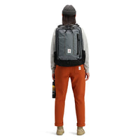 Back model shot of Topo Designs women's boulder pants in "brick" orange