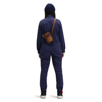 General back shot of Model wearing Topo Designs Women's Coverall jumpsuit in "Navy" blue. 