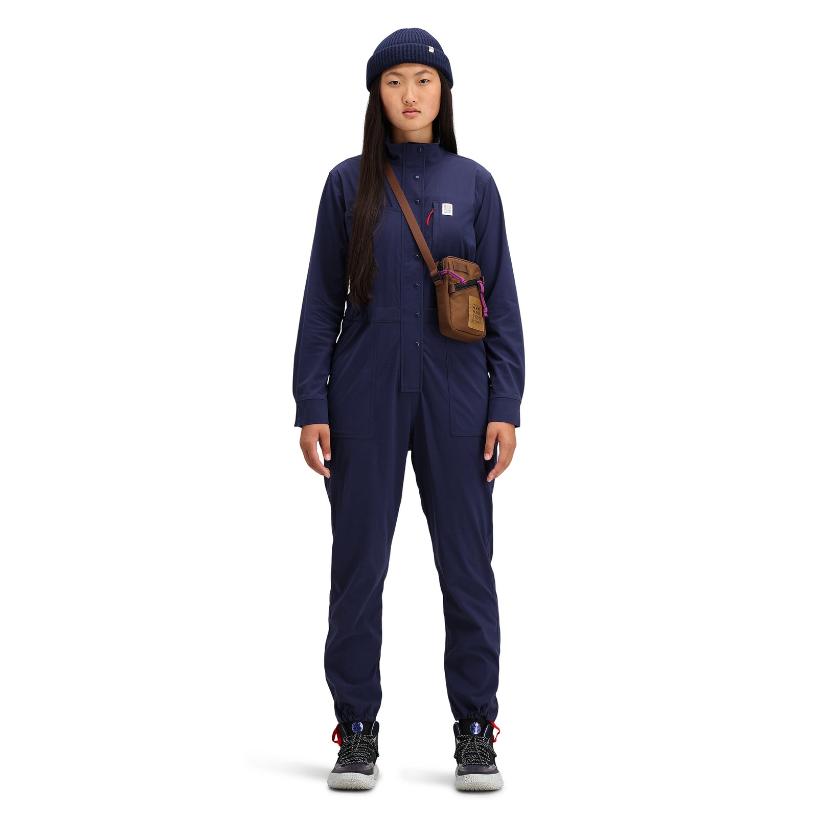 General front shot of model wearing Topo Designs Women's Coverall jumpsuit in "Navy" blue. 