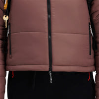 Front model shot of Topo Designs Women's Puffer recycled insulated Jacket in "Peppercorn" purple brown showing zipper and hand pockets.
