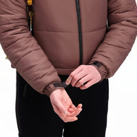 General Front model shot of Topo Designs Women's Puffer recycled insulated Jacket in "Peppercorn" purple brown showing velcro adjustable cuffs.