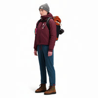 Side model shot of Topo Designs Women's Puffer Primaloft insulated Hoodie jacket in "burgundy" red.