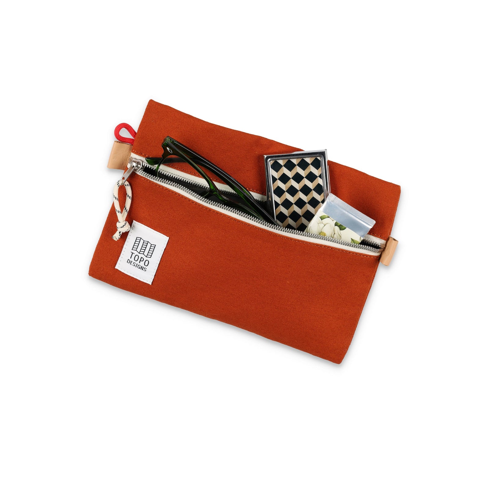 Topo Designs Accessory Bag "Medium" in "Clay" orange canvas to with sunglasses and other items to show size.