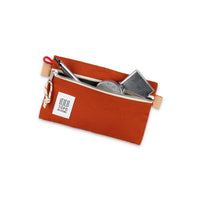 Topo Designs Accessory Bag "Small" in "Clay" orange canvas with pen and other props to show size.