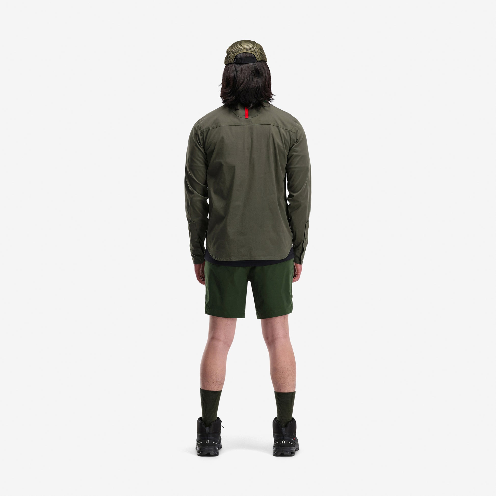 Back model shot of Topo Designs Men's Global lightweight quick dry travel Shorts in "Olive" green.