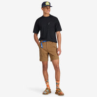 General model wearing Topo Designs Men's Mountain organic cotton Shorts in Dark Khaki brown.