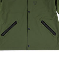 General shot of front hand zipper pockets on Topo Designs Men's Tech Breaker Jacket 4-way stretch windbreaker in olive green.