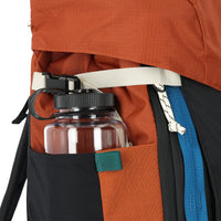 General shot of nalgene water bottle inside expandable side pockets of Topo Designs Mountain Pack 28L hiking backpack with external laptop sleeve access in lightweight recycled clay orange black nylon.