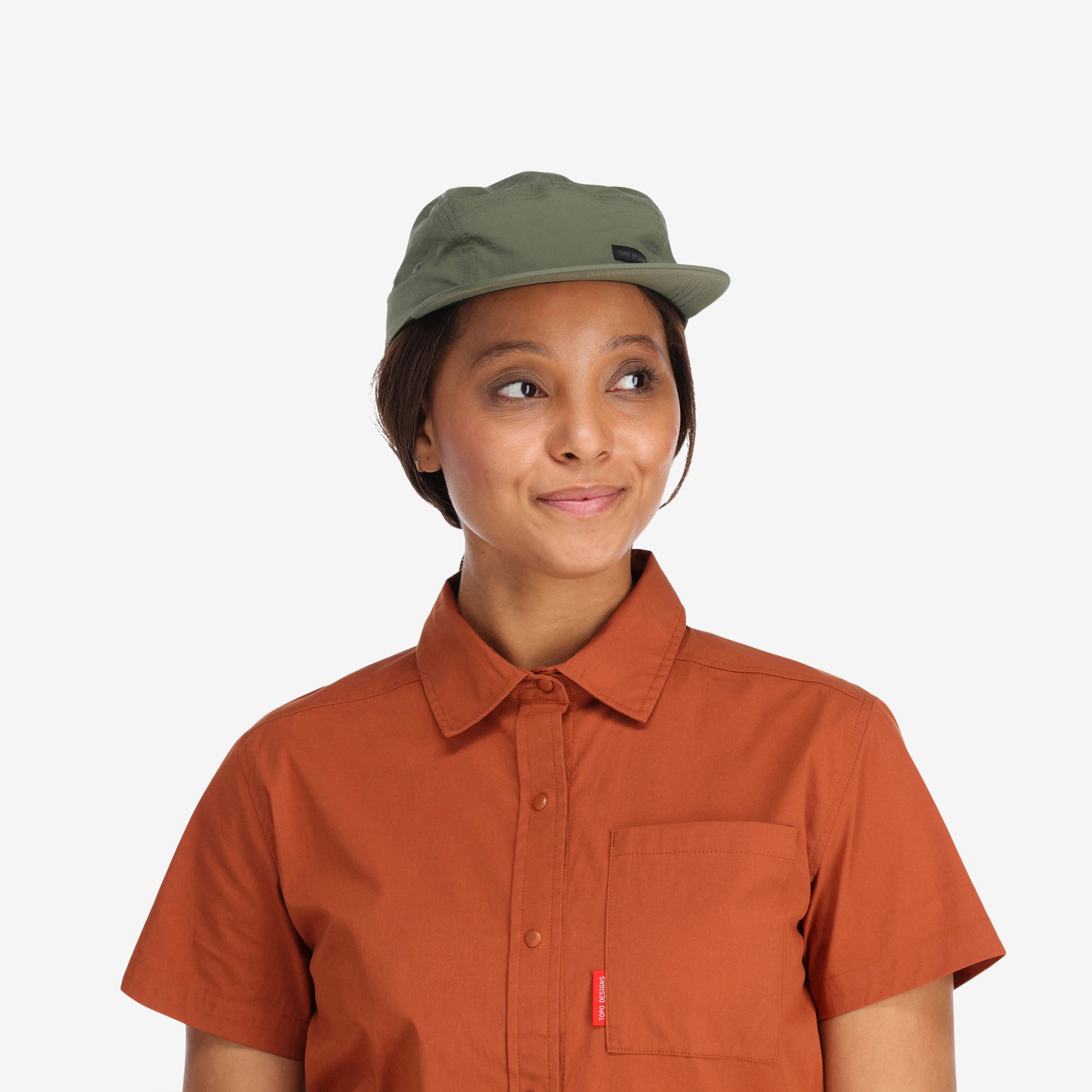 Front model wearing Topo Designs Nylon Camp 5-panel flat brim Hat in "olive" green.