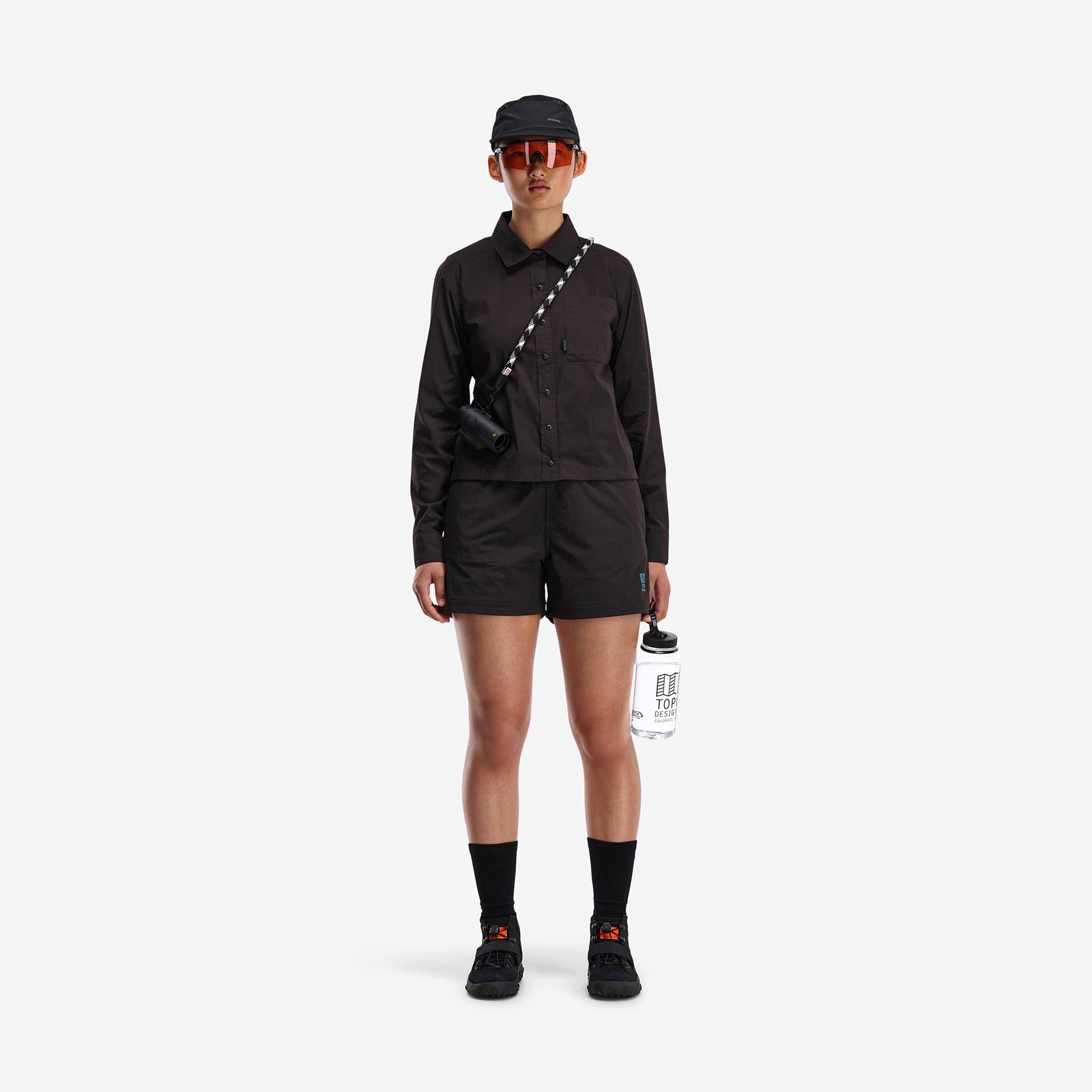 Front model shot of Topo Designs Women's Global long sleeve lightweight snap travel shirt in "black"