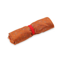 General shot of Topo Designs Women's 30+ UPF moisture wicking River Tank top in clay orange terrazzo print rolled into PackFast packing band for travel.