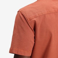 General shot of Topo Designs Men's Short Sleeve Dirt Shirt in "Brick" orange closeup.