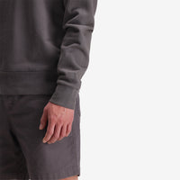 General left arm cuff, model shot of Topo Designs Men's Dirt Crew sweatshirt in 100% organic cotton in "charcoal" grey.