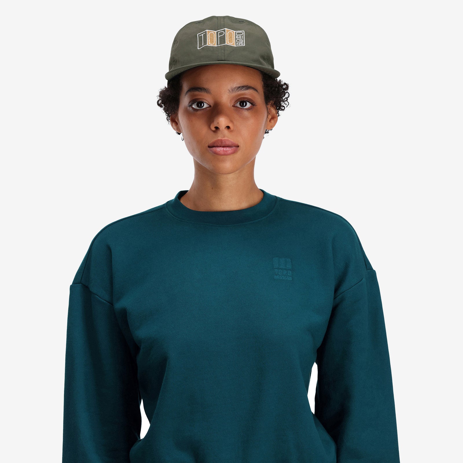 General shot, on model, front photo of Topo Designs Nylon Ball Cap Stacked Map embroidered logo hat in "forest" green