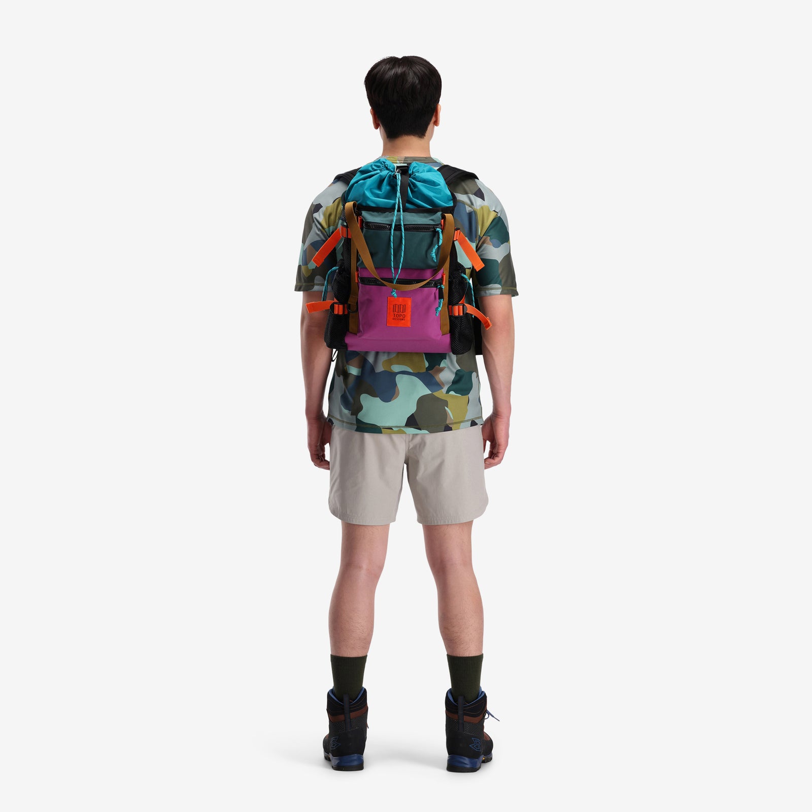 Back view of model wearing the Topo Designs River Bag cinch top tote backpack with mesh sides in "Botanic Green / Grape" green recycled nylon.