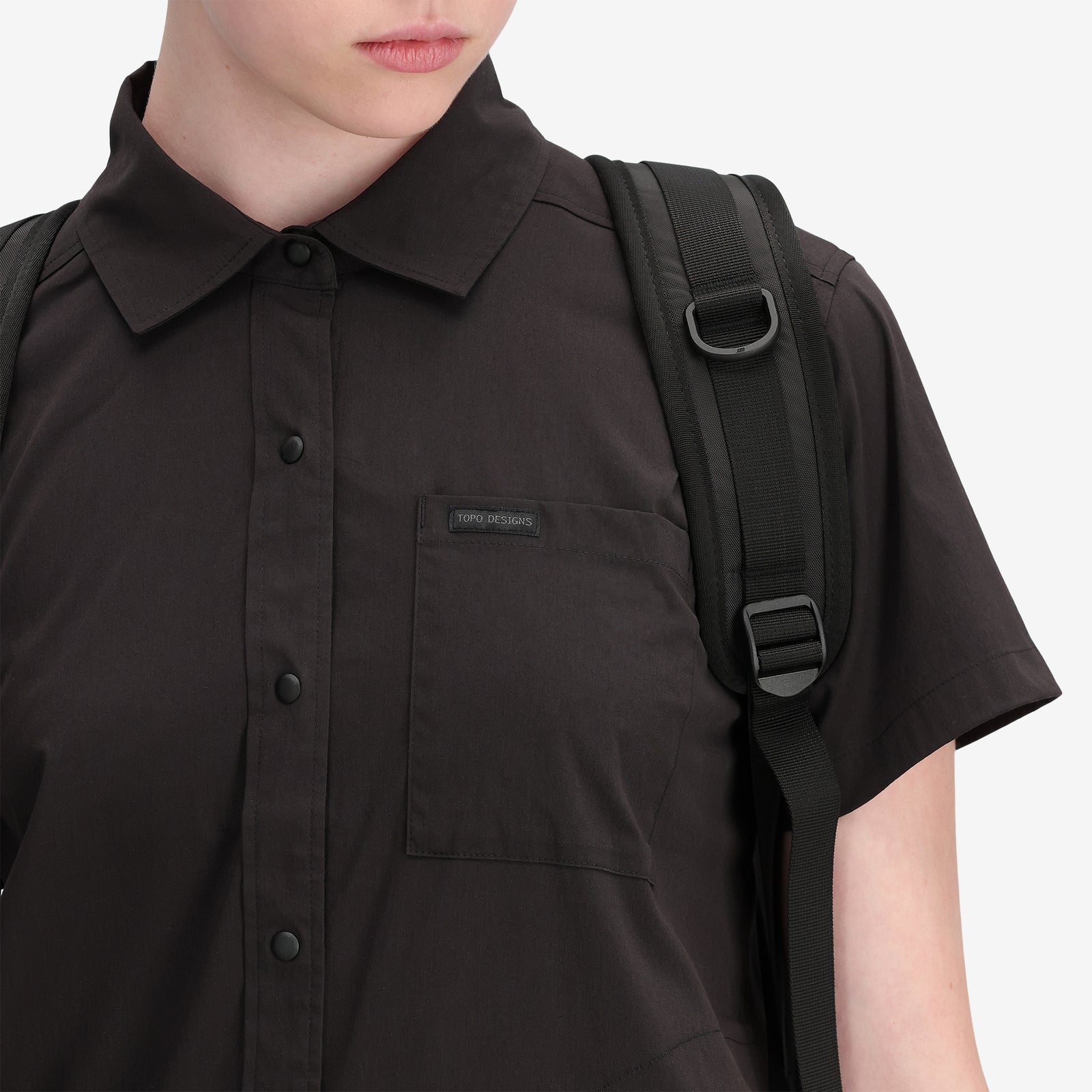 General shot, front pocket of Topo Designs Women's Global Shirt Short Sleeve 30+ UPF rated travel shirt in "Black".