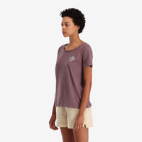 On model left side view of Topo Designs Women's Small Diamond Tee 100% organic cotton short sleeve graphic logo t-shirt in "peppercorn" purple brown.