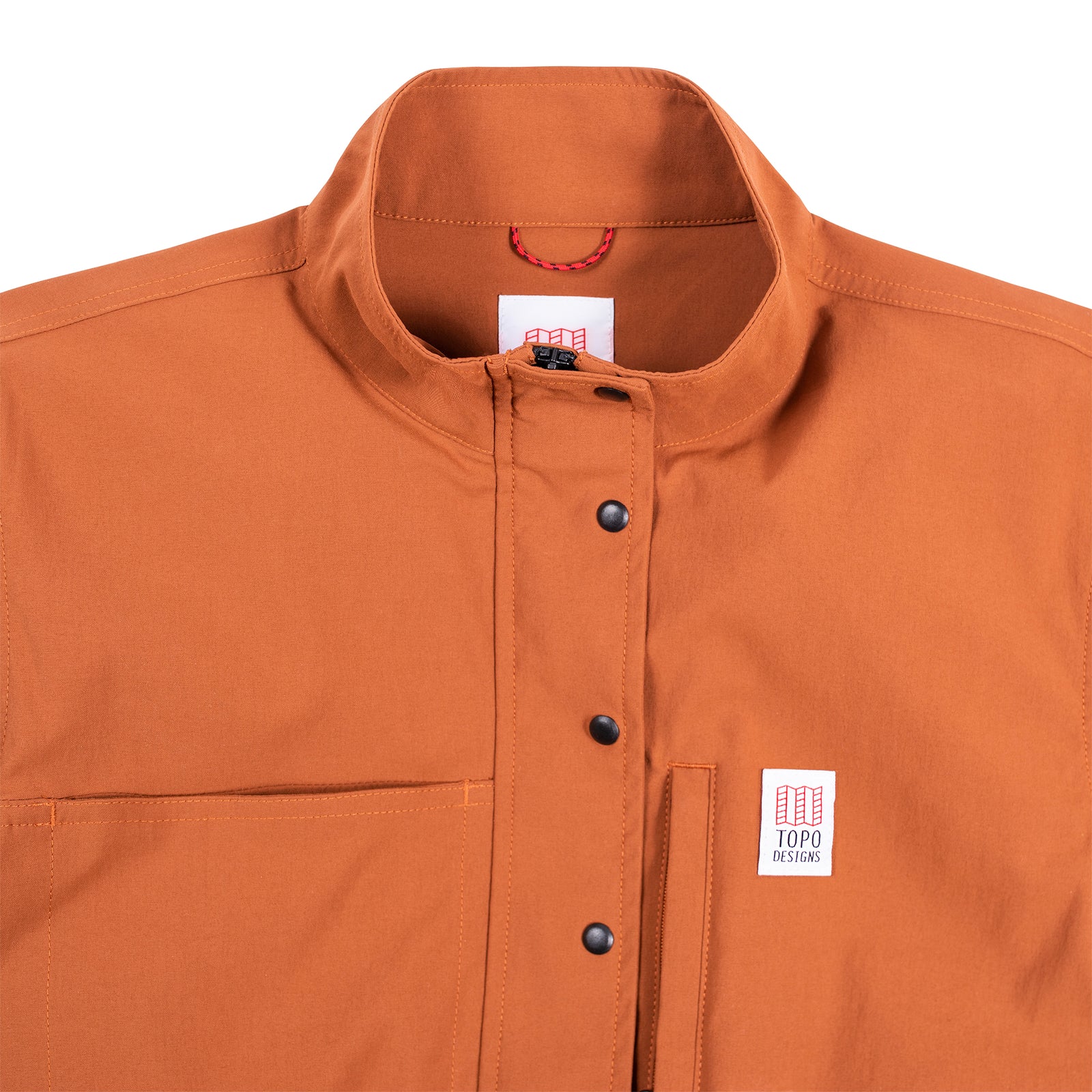 General detail shot of the Topo Designs Women's Coverall in Brick showing front snaps closed.